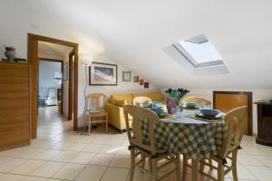 a kitchen and dining room with a table and chairs at Mansarda di Ponente in Caorle