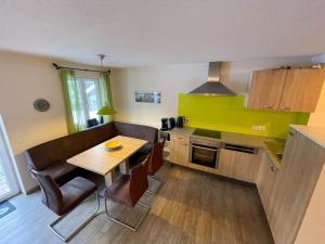 a kitchen with a table and chairs and a dining room at Ferienwohnung Sonnenaufgang in Amtzell