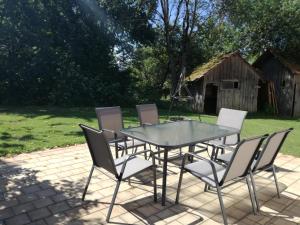 a glass table and chairs on a patio at Ferienwohnung Sonnenaufgang in Amtzell