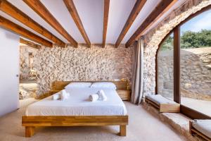 a bedroom with a bed and a stone wall at Can Estela in Sencelles +37 photos
