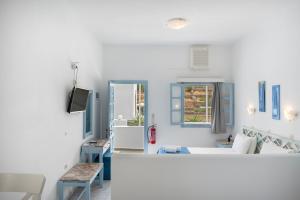 a white room with a bed and a desk at Pico Bello Patmos 22 in Patmos