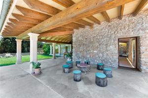 an outdoor patio with stools and a stone wall at Can Estela in Sencelles