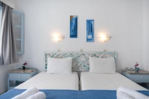 a bedroom with two beds and two night stands at Pico Bello Patmos 22 in Patmos