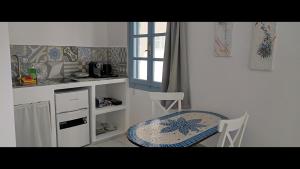 a kitchen with a table and a table and chairs at Pico Bello Patmos 22 in Patmos
