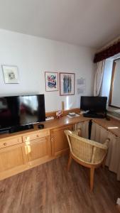 a room with a desk with a television and a chair at Ferienwohnung Älple im Sonnenpark in Bad Hindelang
