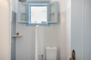 a bathroom with a blue window and a toilet at Pico Bello Patmos 22 in Patmos +20 photos