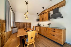 a kitchen with wooden cabinets and a wooden table and chairs at Grogg 608 Apt I I in Martello +14 photos