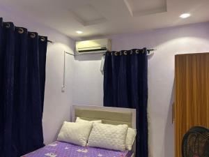a bedroom with a bed with a blue curtain at Lux Apartment in Agege