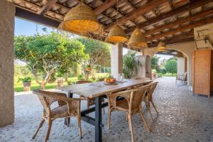 an outdoor dining room with a wooden table and chairs at Finca Cas Forner in Islas Baleares