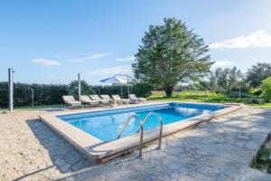 a swimming pool in a yard with chairs and trees at Finca Cas Forner in Islas Baleares