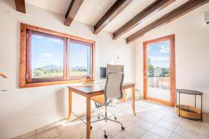 an office with a desk and a chair and windows at Finca Cas Forner in Islas Baleares