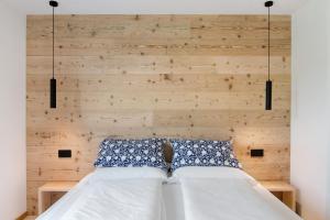 a bedroom with a bed with two blue and white pillows at La villa del lago in giardino in Colico +27 photos