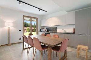 a kitchen with a wooden table and chairs at La villa del lago in giardino in Colico