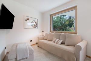 a living room with a couch and a window at La villa del lago in giardino in Colico