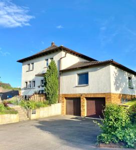 a house with two garage doors in a driveway at Ferienwohnung Alraftsblick in Waldeck