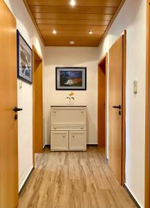 a hallway with white walls and wooden floors and a television at Ferienwohnung Alraftsblick in Waldeck