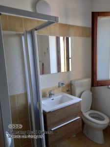 a bathroom with a sink and a toilet and a mirror at Casa Atena in Motta D'affermo
