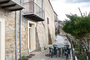 an alley with tables and chairs next to a building at Casa Atena in Motta D'affermo