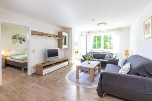 a living room with a couch and a tv at Ferienwohnung Manns in Bettnau