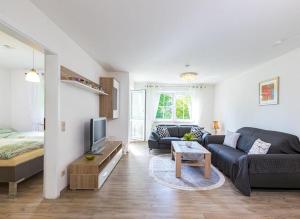 a living room with a couch and a television at Ferienwohnung Manns in Bettnau