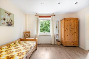 a bedroom with a bed and a window at Ferienhof Ibs in Kronprinzenkoog