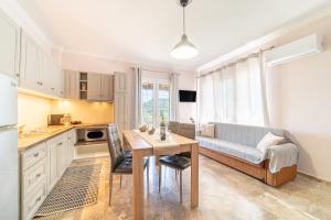 a kitchen and living room with a table and a couch at Villa Logas in Peroulades