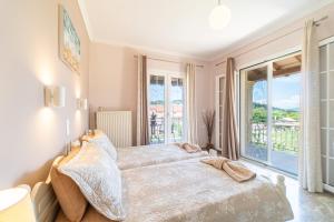 a bedroom with a large bed and a balcony at Villa Logas in Peroulades