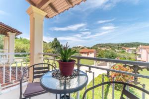 a patio table with a plant on a balcony at Villa Logas in Peroulades
