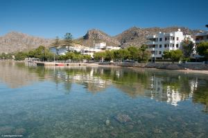 a large body of water with buildings and trees at Ca la Pradina in Pollença