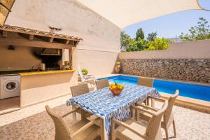 a patio with a table and chairs and a swimming pool at Ca la Pradina in Pollença