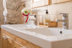 a white sink in a bathroom with a vase of flowers at Ca la Pradina in Pollença +21 photos