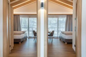 a bedroom with two beds and a table with chairs at Les Ciases Chalets Dolomites Apt 4 in San Vigilio Di Marebbe