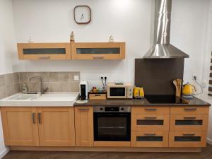 a kitchen with a sink and a microwave at La Maison de violette meublé classé 3 étoiles in Montdidier
