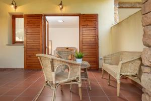 a patio with wicker chairs and a table with a plant at Holiday house li Piri in San Teodoro