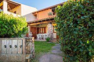 a house with a large green bush in front of it at Holiday house li Piri in San Teodoro
