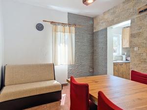 a dining room with a wooden table and red chairs at Holiday Home Marica by Interhome in Tkon