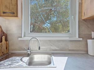 a sink in a kitchen with a window at Holiday Home Marica by Interhome in Tkon +15 photos