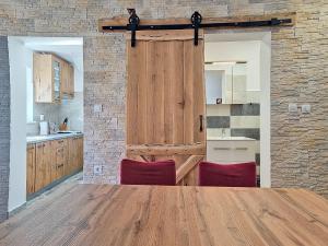 a kitchen with a wooden table and two red chairs at Holiday Home Marica by Interhome in Tkon