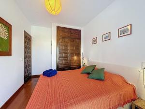 a bedroom with a bed with two green pillows at Holiday Home Salins by Interhome in Empuriabrava