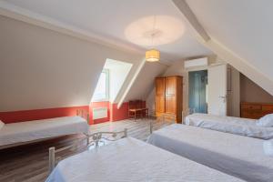 a attic room with two beds and a table at Gite d'Ayzi in Ouzous