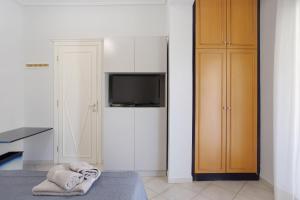 a bedroom with a bed and a tv and a closet at Olympia Holiday Home in Zakynthos