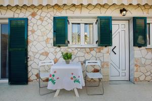 a table and chairs in front of a building at Olympia Holiday Home in Zakynthos