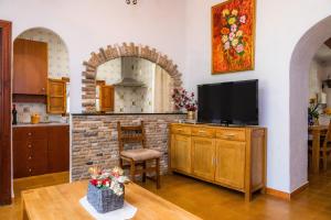 a living room with a tv and a brick fireplace at Can Company in Campanet