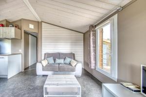 a living room with a couch and a window at Chalet parc nature océan in Hourtin