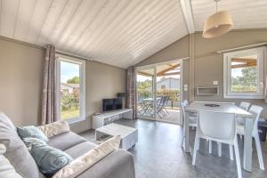 a living room with a couch and a table at Chalet parc nature océan in Hourtin