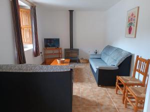 a living room with a couch and a tv at Antiga escola de Molinell in Culla
