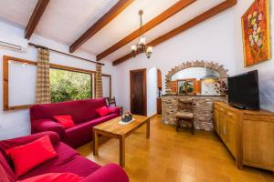 a living room with a red couch and a fireplace at Can Company in Campanet