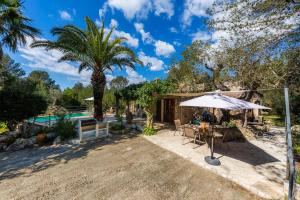 an outdoor patio with an umbrella and a pool at Can Company in Campanet