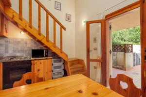 a kitchen with a wooden table and a staircase at Residence Asfodeli E4 in San Teodoro