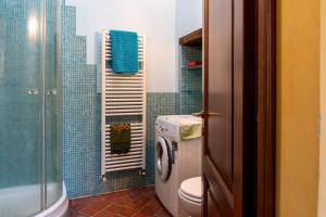 a bathroom with a toilet and a washing machine at Small Rustic Apartment in Scrofiano +17 photos